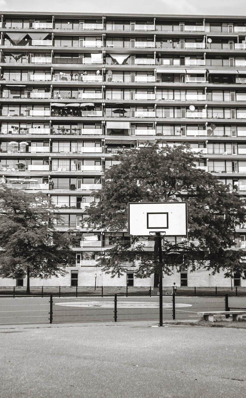 Empty basketball court in front of appartment building in black and white