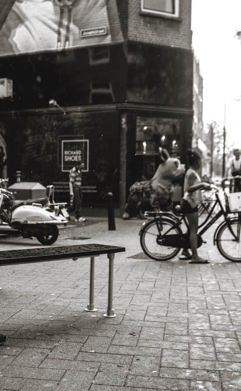 People on bikes in front of store in black and white